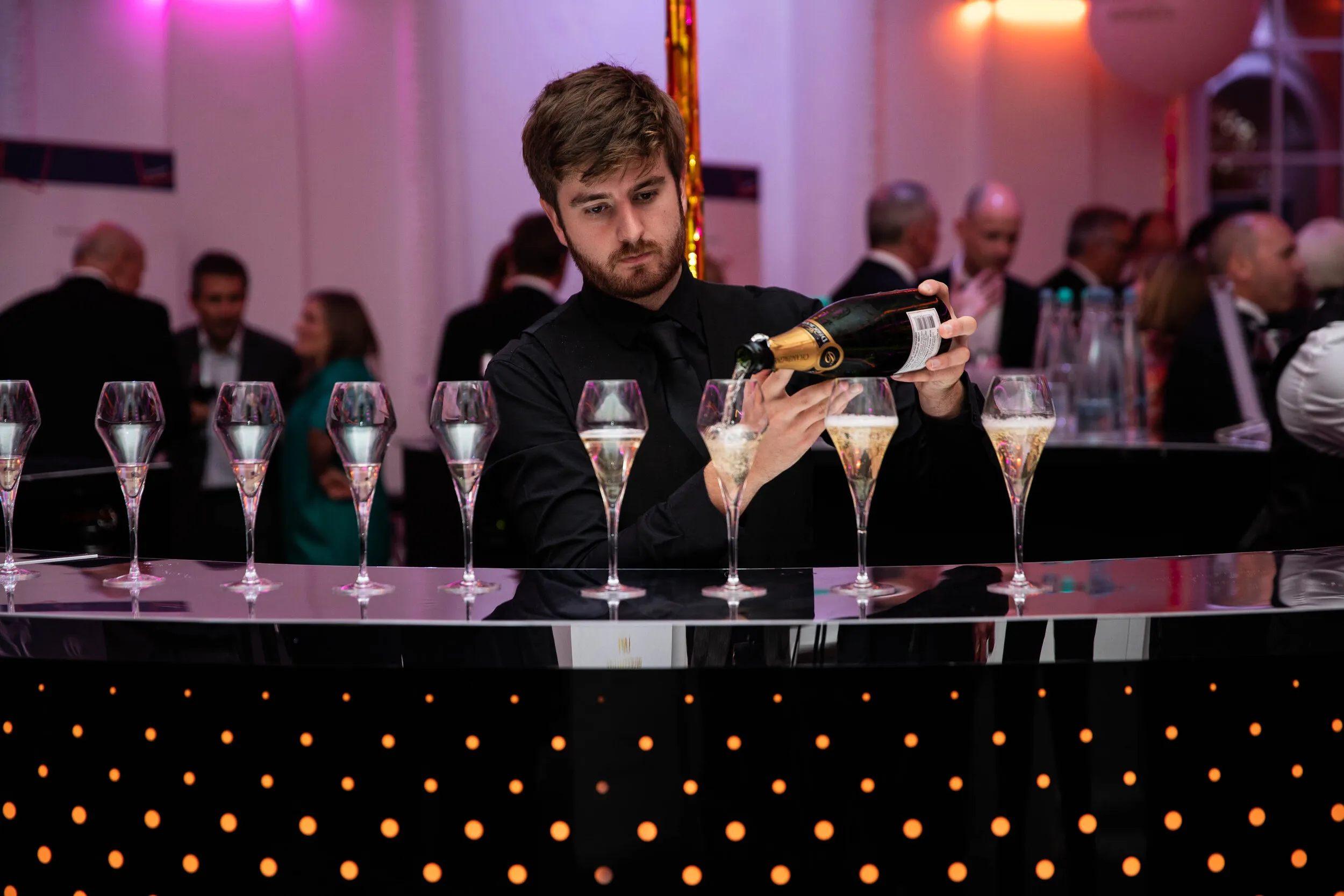 Bartender pouring champagne at a corporate gala dinner, London event photography