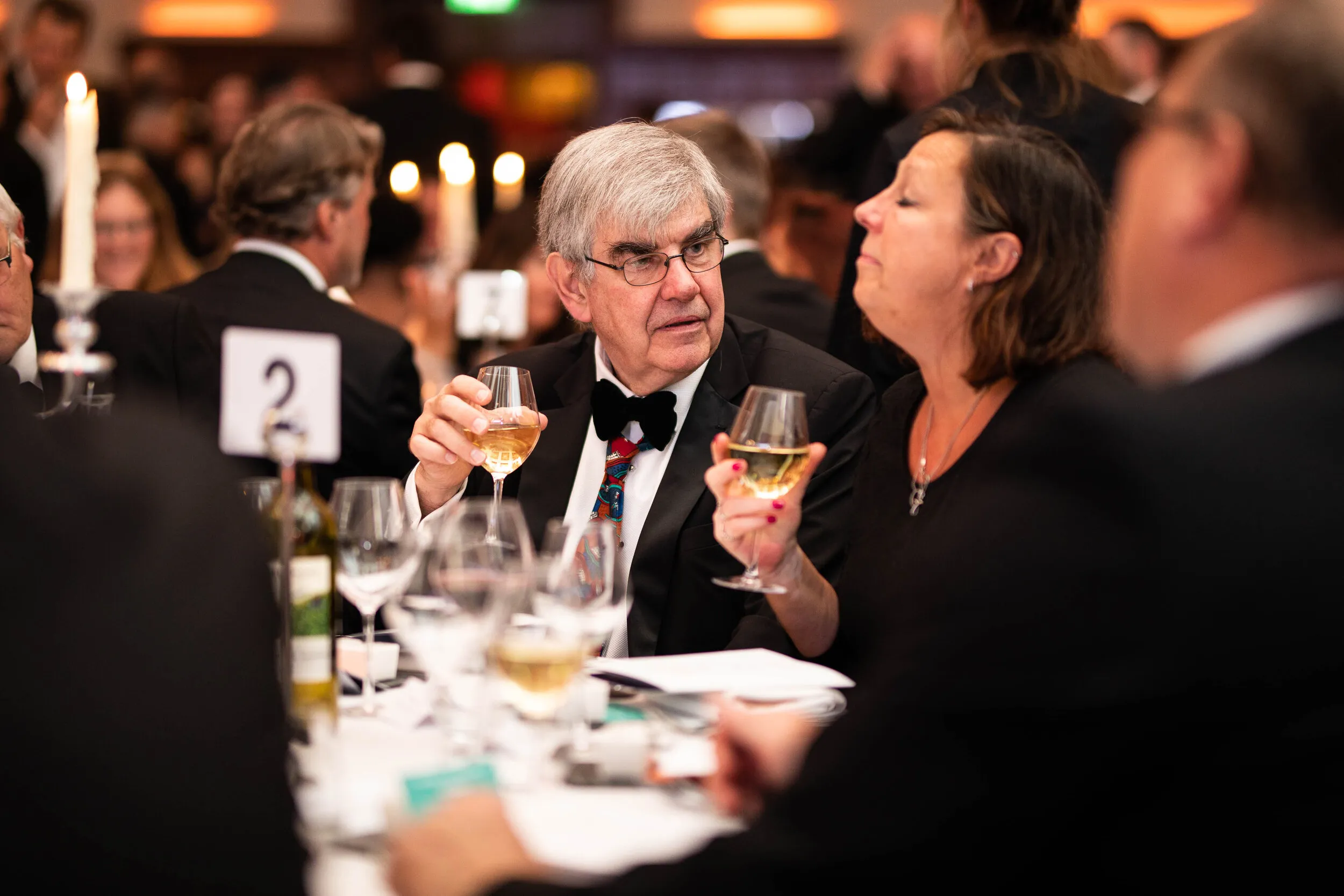 Black tie gala dinner with candlelit networking tables, London corporate event photography