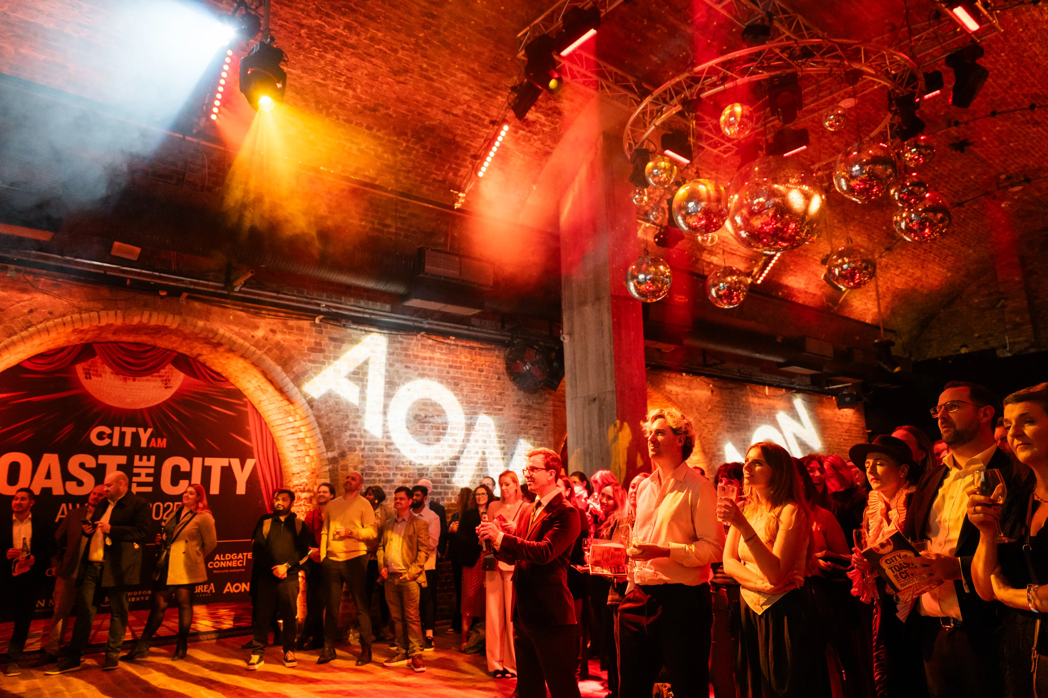 Corporate event photography — awards ceremony crowd under atmospheric disco ball lighting, London