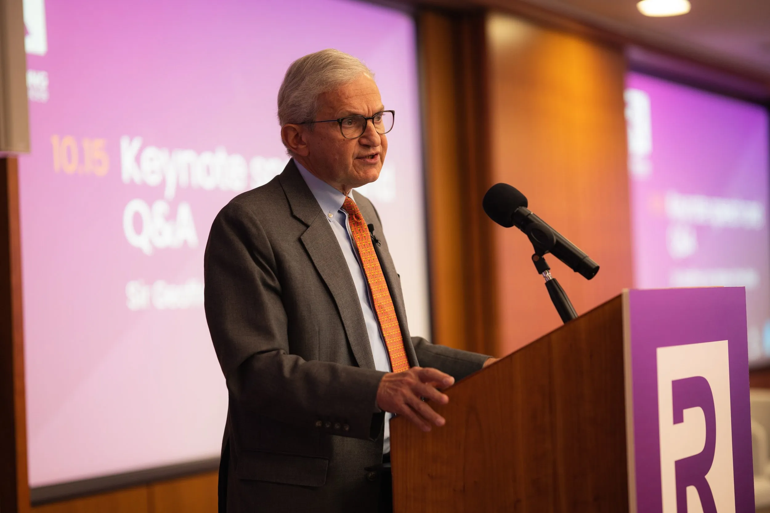 Senior keynote speaker at podium during a legal services conference, London conference photography
