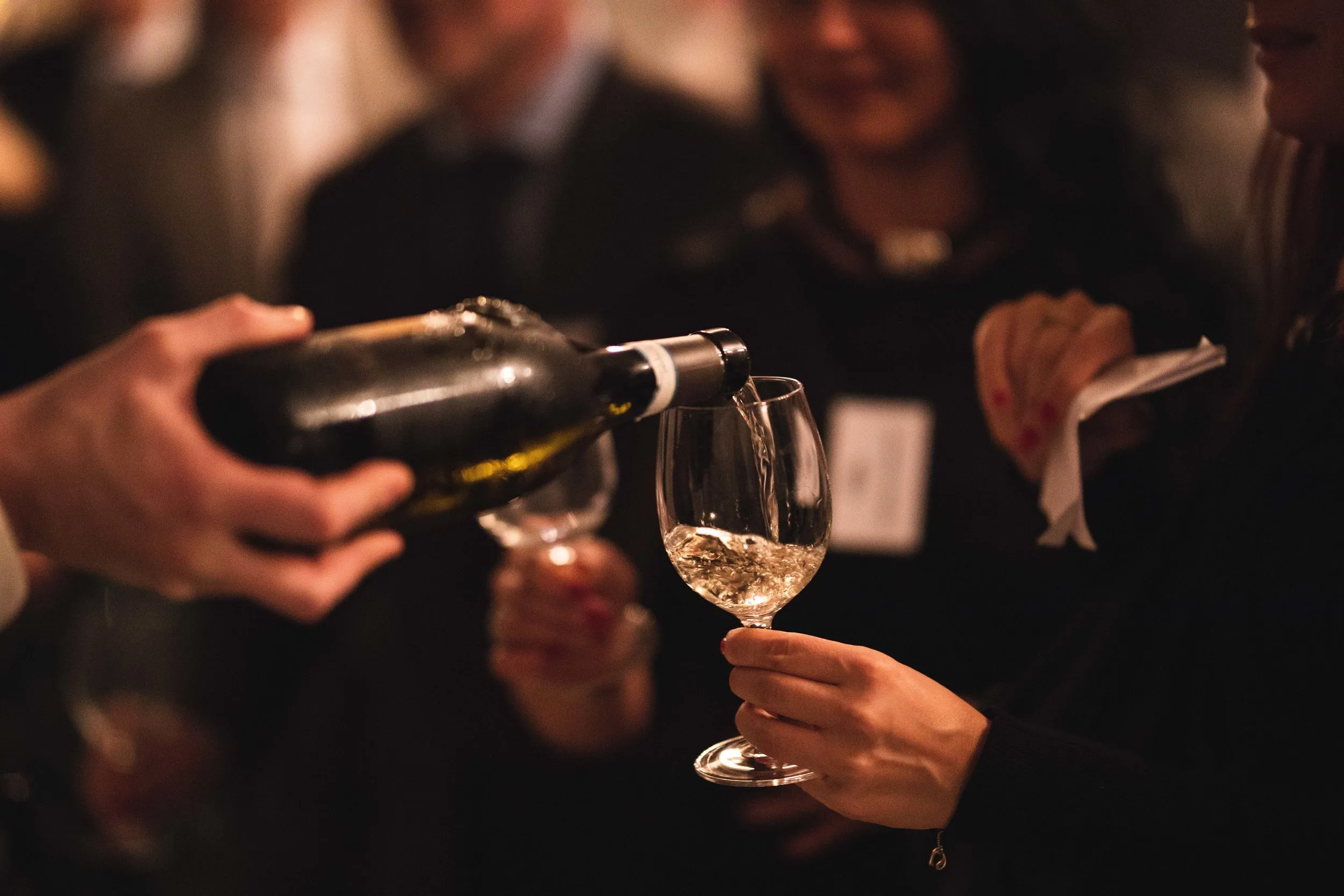 White wine being poured at a corporate networking drinks event, London