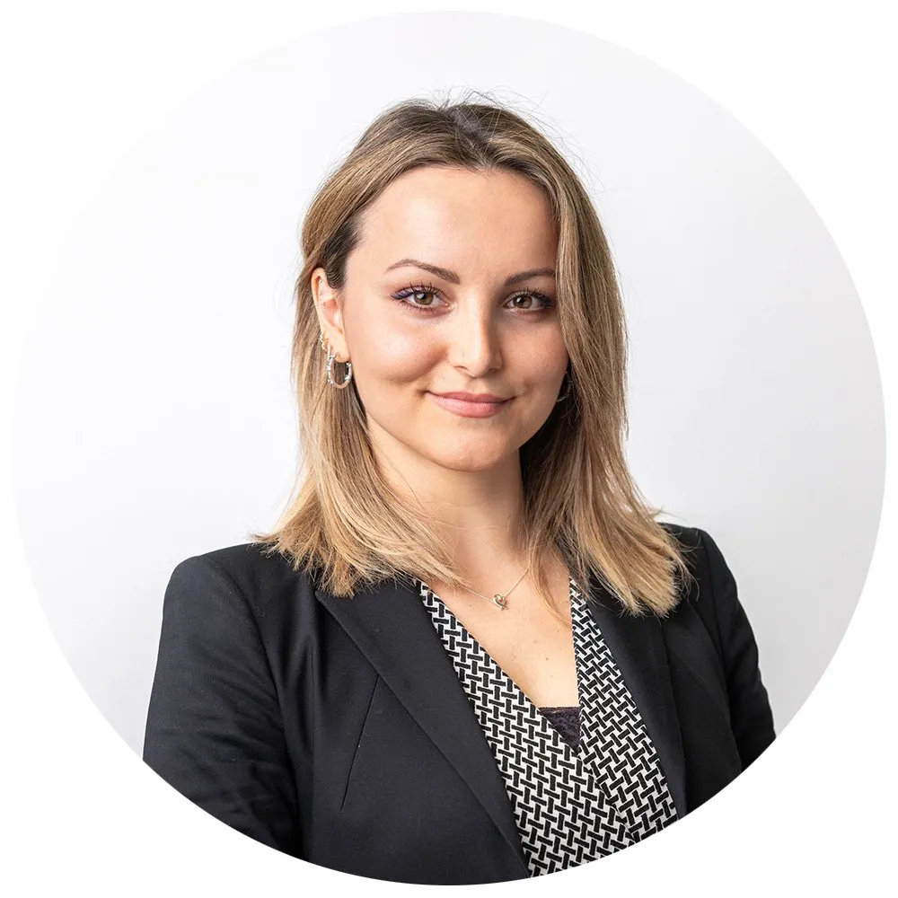 Corporate headshot of blonde woman in black blazer with patterned top, London