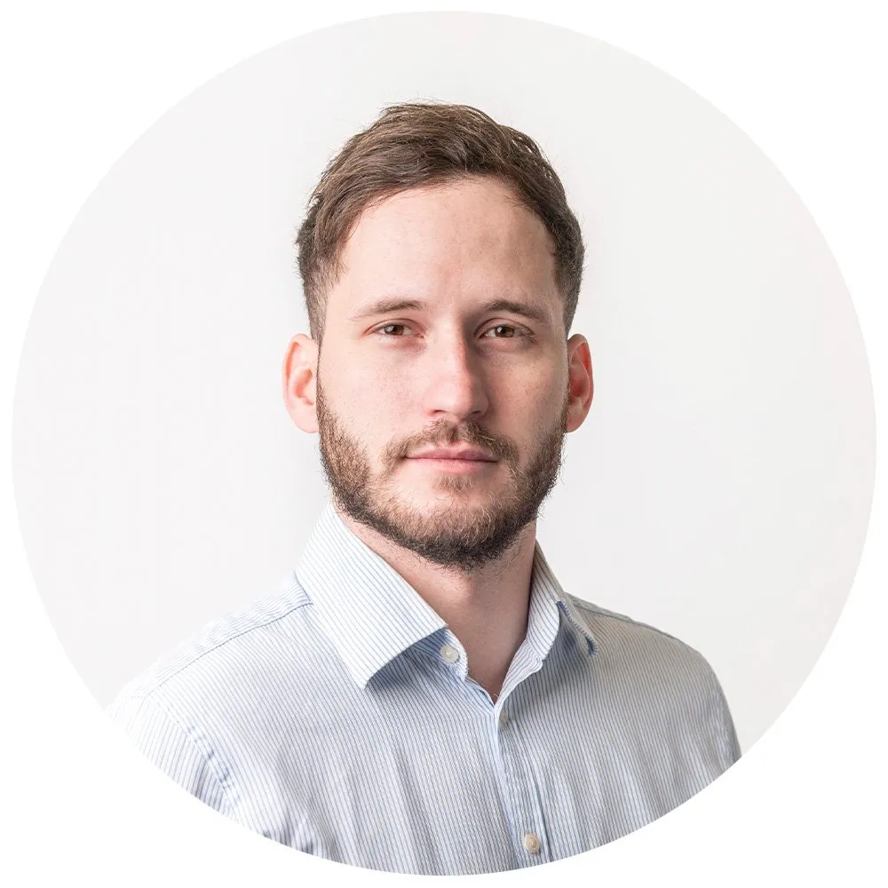 Corporate headshot of man with beard in blue striped shirt, London