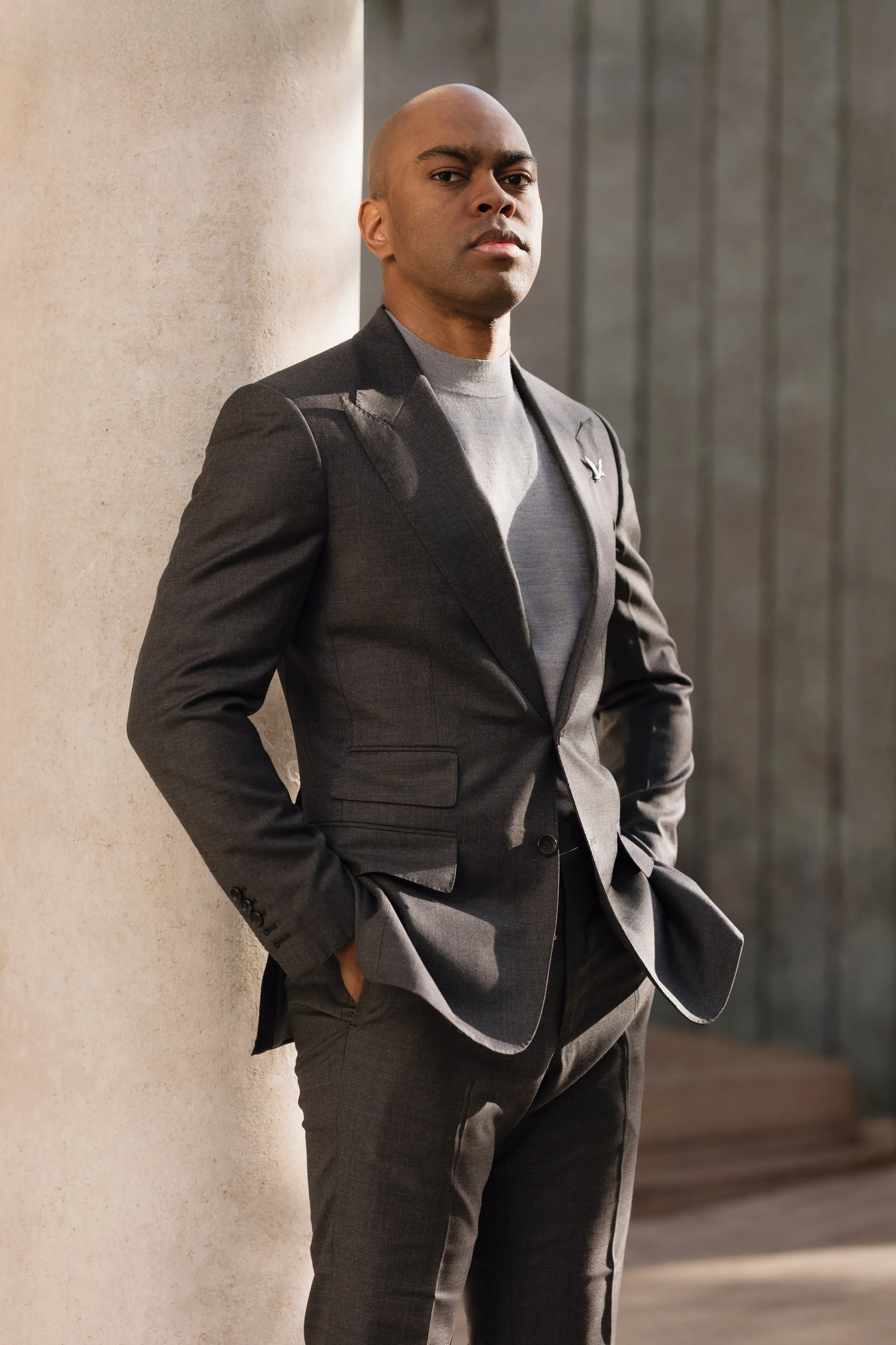 Corporate headshot of man in charcoal suit and grey turtleneck at outdoor location, London