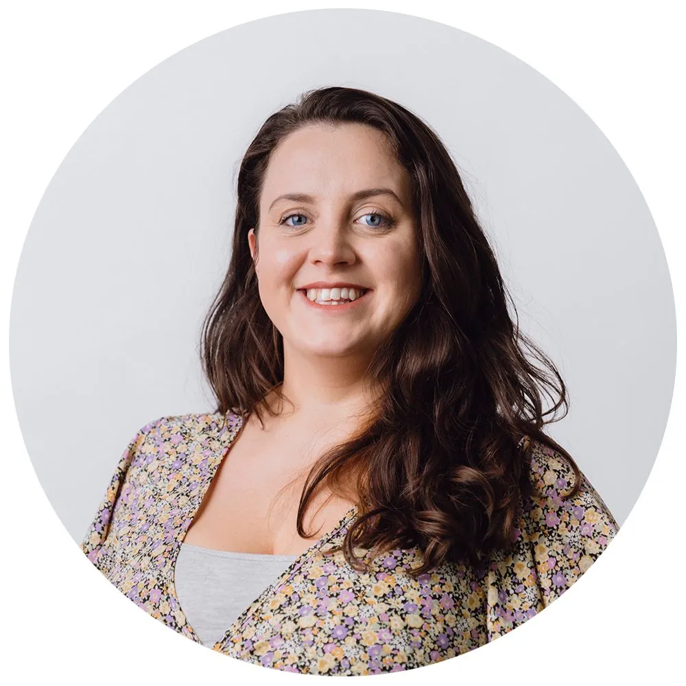 Professional headshot of woman with dark hair in floral jacket, London