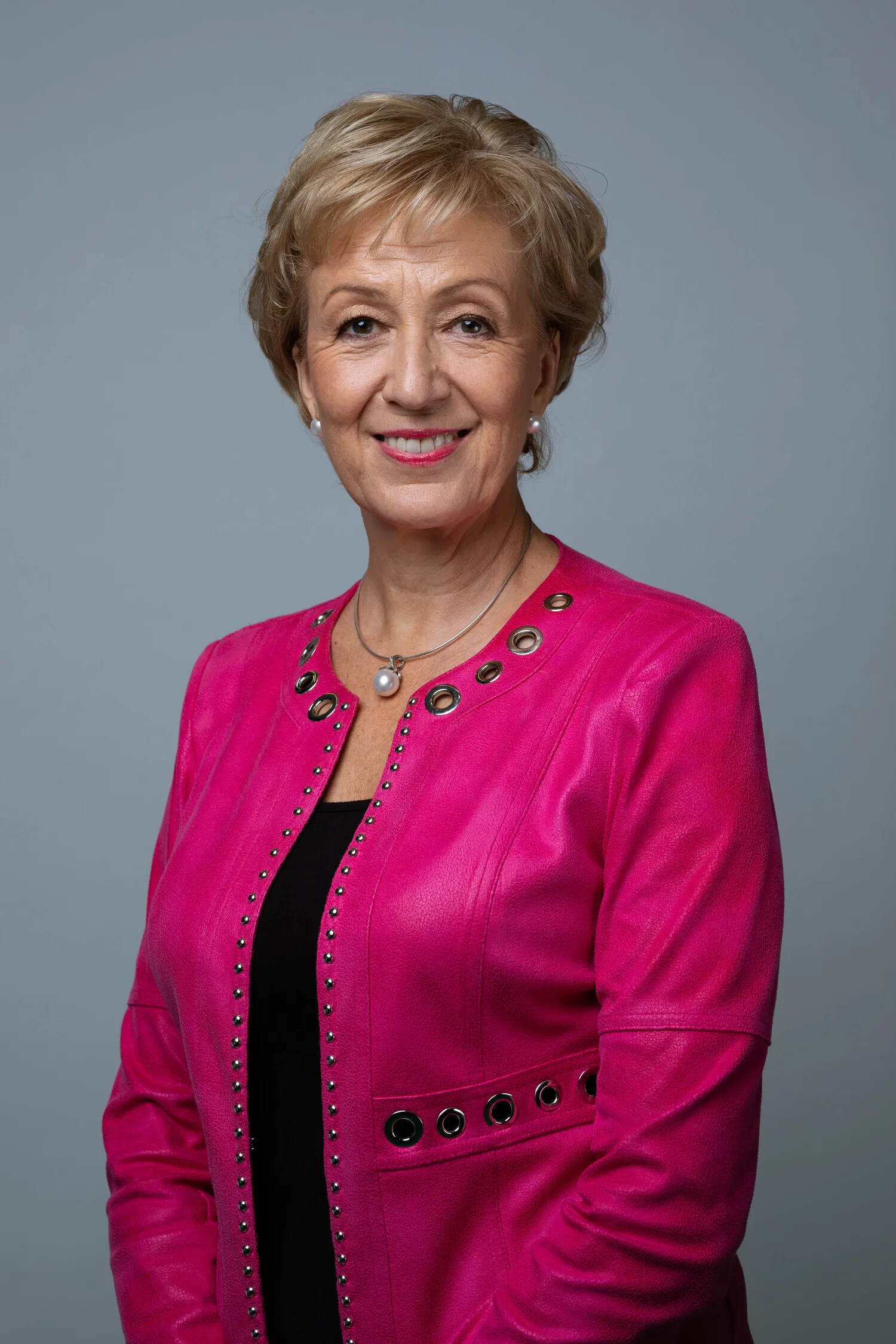 Professional headshot of woman in pink jacket, London