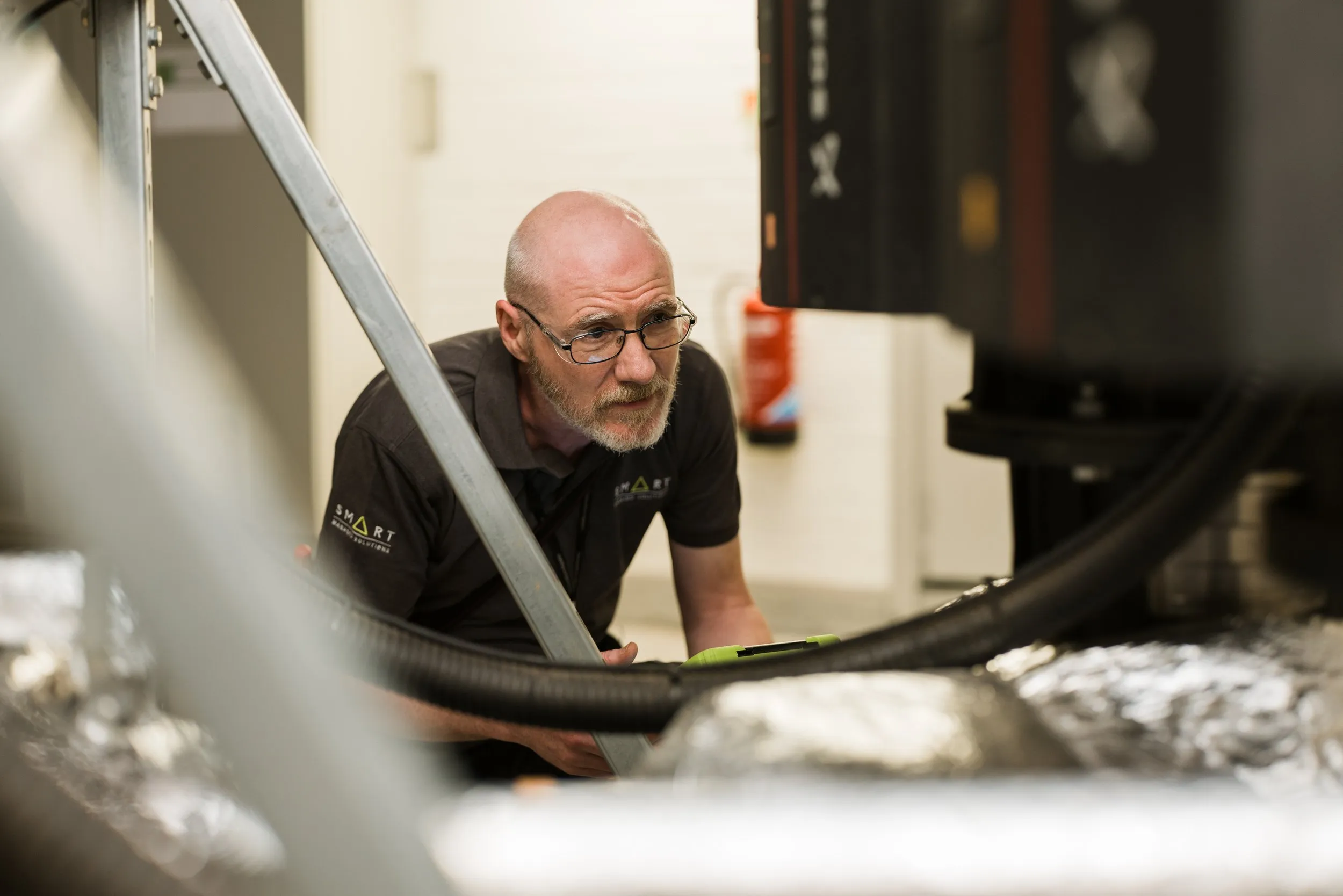 Maintenance engineer working on industrial machinery, corporate branding photography, London