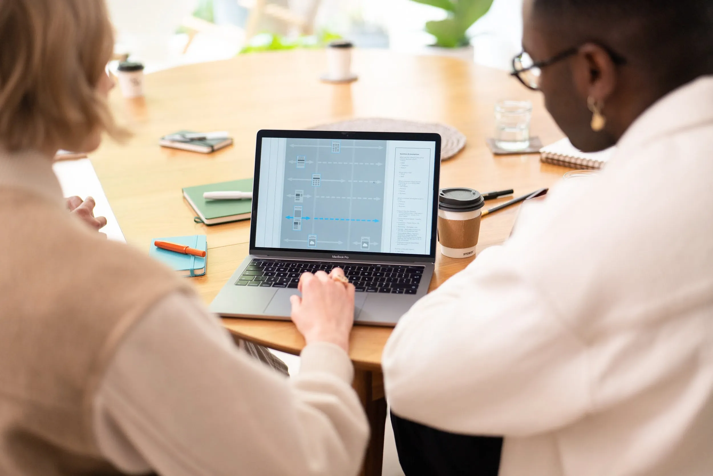 Two colleagues reviewing UX design on a laptop, corporate branding photography, London