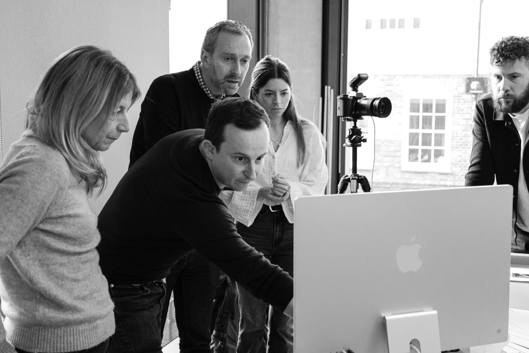 Publicis Pro agency team reviewing corporate photography selects on monitor — collaborative shoot debrief in London office